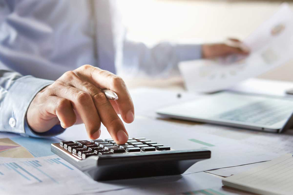 photo of business person using calculator